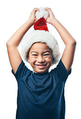 Image showing Christmas hat, face and excited child with celebration and funny portrait isolated on transparent png background. Happy, play and asian kid or boy celebrate holiday, arms in air and take off costume