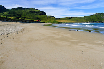 Image showing Beach by the coast with green grass up the hill