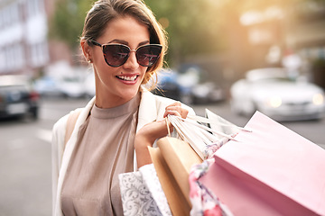 Image showing Fashion, shopping bag or rich girl in city or urban street for boutique retail sale or clothes discount deals. Sunglasses, financial freedom or trendy customer walking on road with luxury products