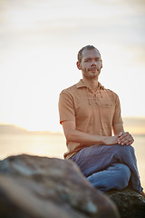 Image showing As tranquil and peaceful as nature. Shot of a peaceful man sitting on a rock at the beach.