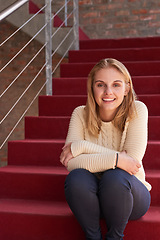 Image showing Campus life. Portrait of a university student sitting on a staircase at campus.