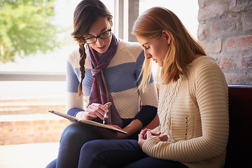 Image showing Preparing for an upcoming test. Shot of two university students looking through some notes together on campus.