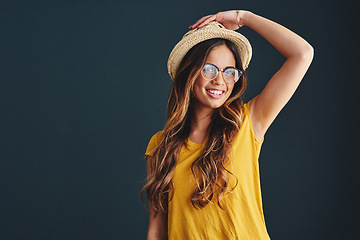 Image showing Im ready for hats and sunny days. Studio shot of an attractive young woman against a dark background.