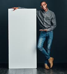 Image showing Are you interested. Shot of a handsome young man standing next to a blank placard.