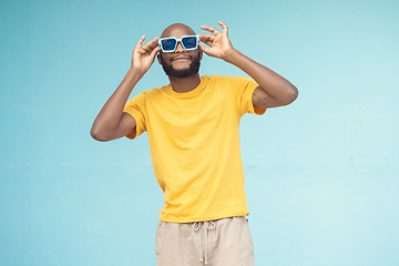Image showing Sunglasses, black man and fashion on a blue background with cool and trendy style with mock up space. Young model person with eyewear in studio for advertising designer brand, logo or color in hands