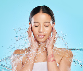 Image showing Skincare, water and face of woman for wellness, healthy skin and cleaning in studio. Bathroom, shower and female person with eyes closed for facial grooming, washing and beauty on blue background