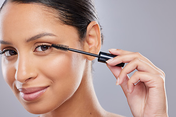 Image showing Portrait, mascara and woman with brush in studio for makeup, cosmetics and results on grey background. Eyelash, beauty and face of Indian female model with tool for treatment, application or volume