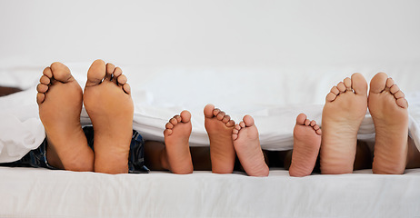 Image showing Love, bed and closeup of family feet relaxing, laying and bonding in the bedroom with a blanket. Zoom of a mother, father and children resting or sleeping barefoot together on weekend in their house.