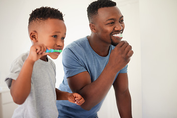 Image showing Father brushing his teeth with his child for oral hygiene, health and wellness in the bathroom. Dental, teaching and young African man doing his morning mouth routine with his boy kid at their home.