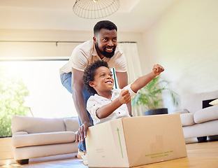 Image showing Father, son and playing at home with pretend car in a box on moving day in new property. Black family, house and real estate move of a dad and child together with play driving and fun in living room