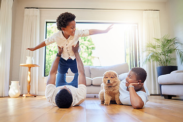 Image showing Dad, mother and home playing airplane together with happiness and puppy with smile. House, family and support of a mom, father and young child with dog and animal in living room having fun on floor