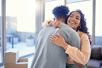 Image showing Happy couple, hug and real estate with key for new home, moving in or mortgage loan together indoors. Woman hugging man with smile in happiness, property or investment with keys to apartment building