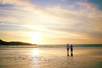 Image showing Couple, sunset and walk by ocean with space for mockup in summer sunshine with love, care and bond on holiday, Man, woman and holding hands with sky background, beach and clouds on romantic vacation