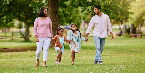 Image showing Park, walk and happy family holding hands, talking and bonding with love, smile and fun in nature. Children, parents and walking in a forest together on the weekend, cheerful and enjoying holiday