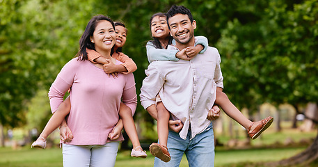 Image showing Portrait, piggyback and happy asian family in a park with love, smile and games in nature. Face, freedom and parents carrying children in a forest, bonding and playing together on the weekend outdoor