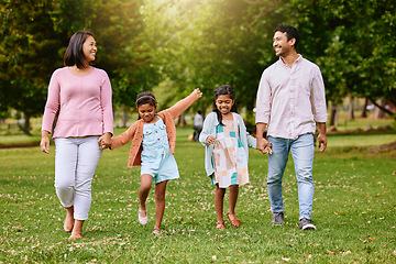 Image showing Park, walk and happy family holding hands, talking and bonding with love, smile and fun in nature. Children, parents and walking in a forest together on the weekend, cheerful and enjoying holiday