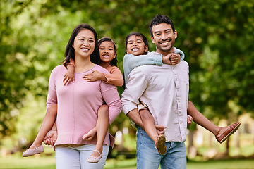 Image showing Piggyback, portrait and asian family in a park happy, smile and having fun while bonding outdoor. Love, hug and face of parents carrying children in a forest, cheerful and playing games in nature