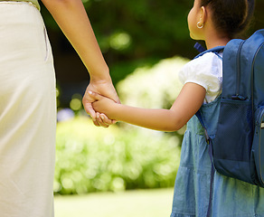 Image showing Backpack, holding hands and child with mother, school and walking together outdoor. Hold hand, mom and student walk, travel and bonding at kindergarten with care, safety or security, support or trust