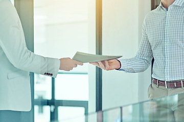 Image showing Doing a handover. Shot of a businessman handing a document to a colleague.