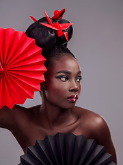 Image showing Beauty, makeup and origami with black woman in studio for creative, art and culture. Traditional, cosmetics and paper design with female model and fans on grey background for oriental, retro or color