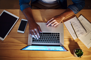 Image showing The tools of greatness. Shot of an unrecognised businessman working late at night on his computer in a modern office.