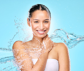 Image showing Water, skincare and shower with portrait of woman in studio for hygiene, beauty and splash. Wellness, cleaning and fresh with face of female model on blue background for spa, cosmetics and liquid