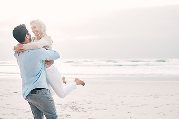 Image showing Beach, love and man carry woman on holiday, vacation and romantic weekend for anniversary. Mockup space, marriage and happy mature couple spin in air for bonding, quality time and romance by ocean