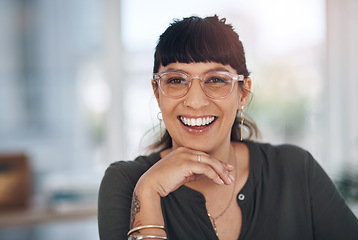 Image showing This is the smile of success. Cropped portrait of an attractive young businesswoman sitting alone in her office with her hand on her chin.