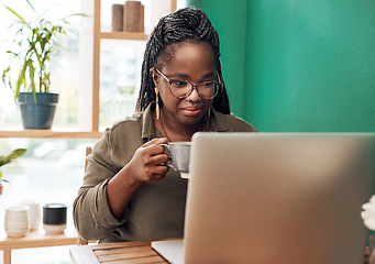 Image showing Coffee is the ultimate bloggers fuel. Shot of a young woman having coffee and using a laptop at a cafe.