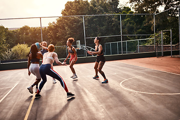 Image showing Trying to get through. Cropped shot of a diverse group of sportswomen playing a competitive game of basketball together during the day.