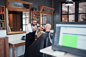 Image showing Im the beard expect in this town. Cropped shot of a handsome young barber trimming and lining up a clients beard inside his barbershop.