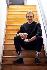 Image showing I need coffee to recharge. Full length portrait of a handsome young businessman sitting on the office staircase and holding a cup of coffee.