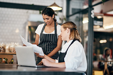 Image showing A connected team keeps the numbers up. Shot of two women using a laptop together while working in a cafe.