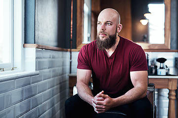 Image showing Today is going to be good day for my business. Cropped shot of handsome young barber sitting on a chair inside his barbershop.