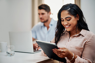 Image showing Facilitating a meeting with awesome functionality. Shot of a young businesswoman using a digital tablet during a meeting in a modern office.