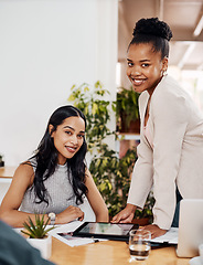 Image showing Theres an app to assist our every need. Portrait of two businesswomen working together on a digital tablet in an office.