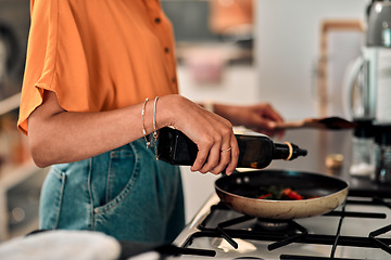 Image showing Hands, cooking and olive oil with a woman in the kitchen of her home for food or meal preparation. Stove, pan and container with a female chef in her house to cook for health, diet or nutrition