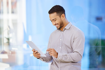 Image showing Technology, man on a tablet and standing with smile in a office at his workplace. Social networking or connectivity, online communication, happiness and male person reading a email or report.