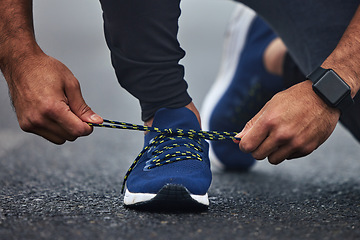 Image showing Man, hands and tie shoes on road for running, fitness or cardio workout on asphalt in the outdoors. Hand of male person, runner or athlete tying shoe and getting ready for sports training on street