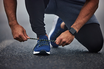 Image showing Man, hands and tying shoes on road for running, fitness or cardio workout on asphalt in the outdoors. Hand of male person, runner or athlete tie shoe and getting ready for sports training on street