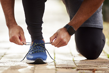 Image showing Man, hands and tie shoe in park for running, fitness or cardio workout and exercise in the outdoors. Hand of male person, runner or athlete tying shoes and getting ready for sports training in nature