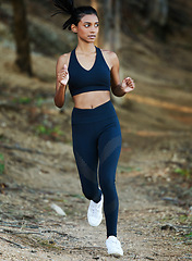 Image showing Woman is running in forest, fitness and cardio in nature with exercise and healthy, active lifestyle. Female runner outdoor, training for marathon with speed, energy and workout for health and sport