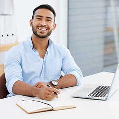 Image showing Portrait, businessman writing in a book and with laptop smile at desk of his modern work office. Success or happiness, write in notebook and excited male person sit at table of his workstation