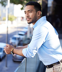 Image showing Thinking, vision and a business man on the balcony of his office looking at the city for inspiration. Future, idea and mindset with a young male employee contemplating a decision in an urban town