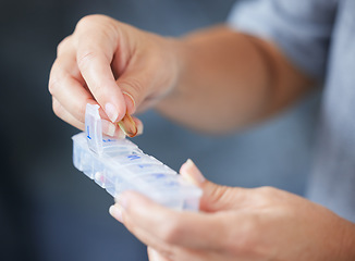 Image showing Hands, container and routine medicine with a woman in her home during retirement closeup for daily vitamins. Healthcare, medical and supplements with an elderly person taking prescription medication