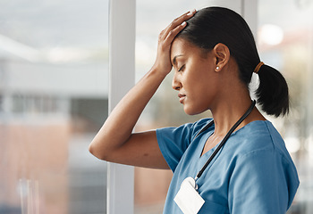 Image showing Mental health, doctor with headache and stress standing at window at hospital. Burnout or overworked, anxiety or depression and female nurse or caregiver holding her head for migraine pain at clinic