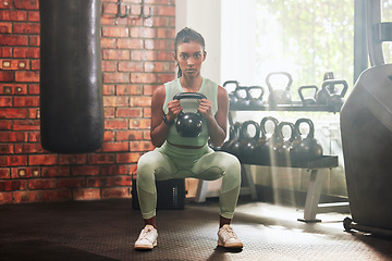 Image showing Fitness, kettlebell and portrait of a woman in the gym doing strength legs and arms training. Sports, exercise and serious female athlete doing a strong squat workout with a weight in a sport center.