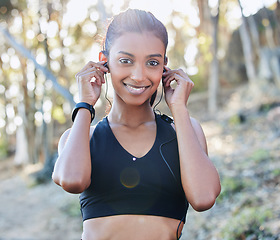 Image showing Sports, portrait and woman with a earphones for music, radio or podcast while running in nature. Fitness, exercise and female athlete doing cardio workout for race or marathon training in the woods.