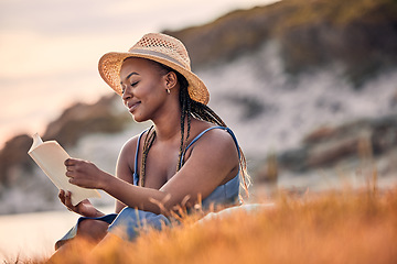 Image showing Nature, mountain and woman reading a book while relaxing outdoor on the grass at sunset in summer. Freedom, travel and calm African female person enjoying a novel or fantasy story on hill with peace.