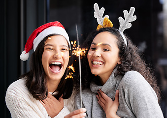 Image showing Women friends, Christmas and sparkle light with smile, home and celebration of festive holiday. Girl, woman and excited with fireworks, celebrate and happiness on vacation, laughing and xmas bonding